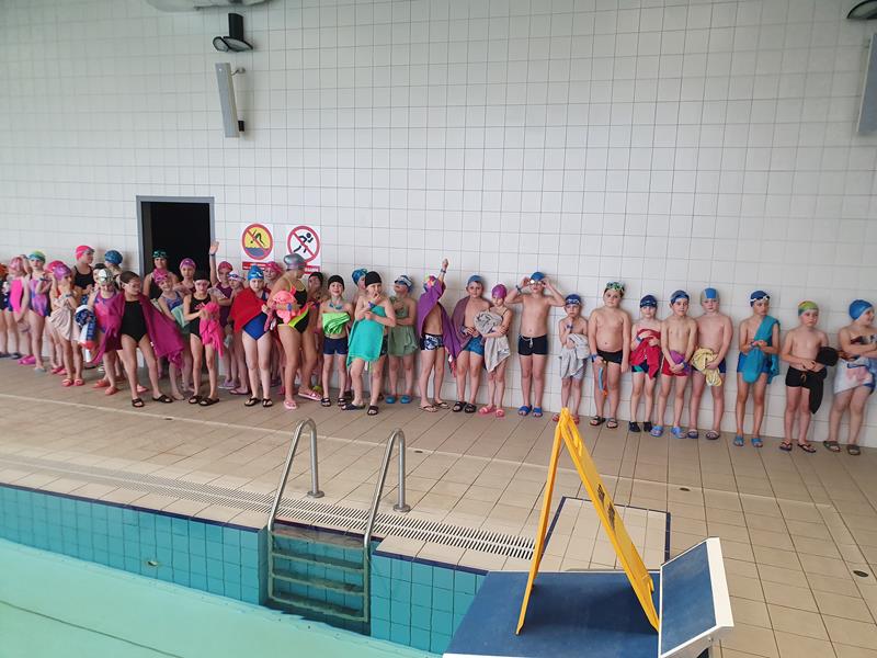 Zdjęcie przedstawiające dzieci podczas zajęć na basenie.