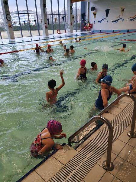 Zdjęcie przedstawiające dzieci podczas zajęć na basenie.