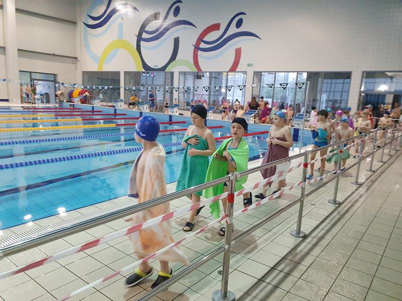 Zdjęcie przedstawiające dzieci podczas zajęć na basenie.